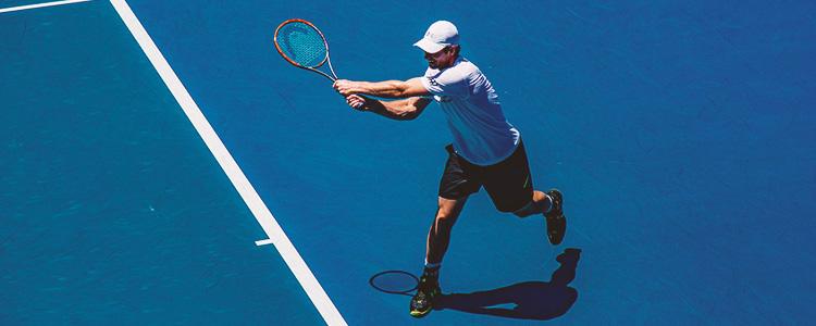 Tennisspieler holt mit dem Schläger aus